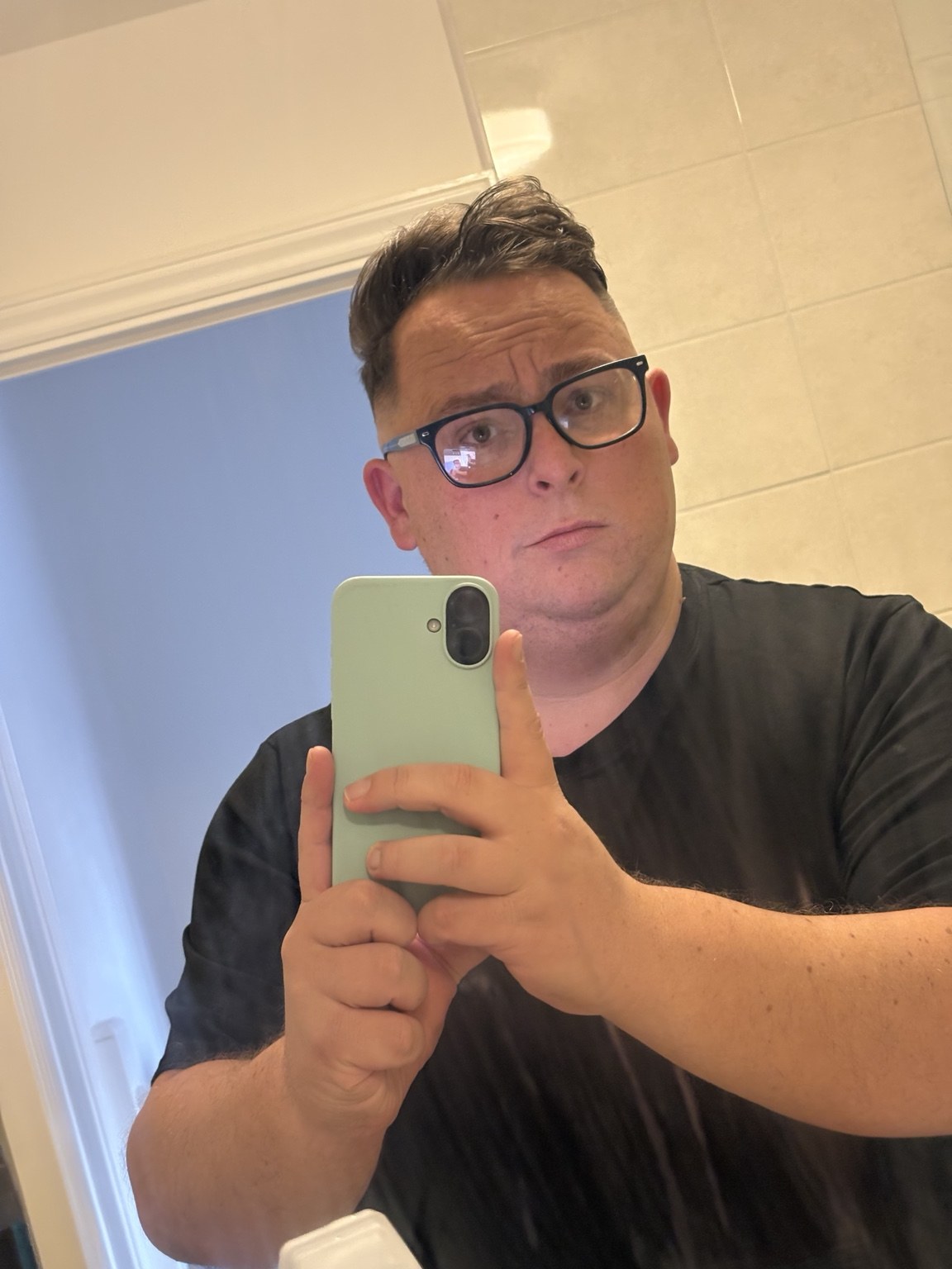 Al Jennings wearing glasses and a black T-shirt in a mirror selfie